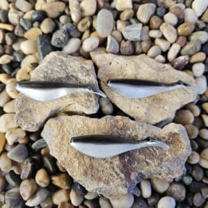 Three silver and black fishing lures.