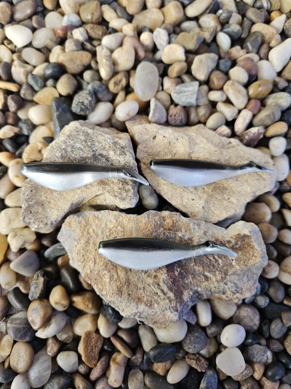 Three silver and black fishing lures.