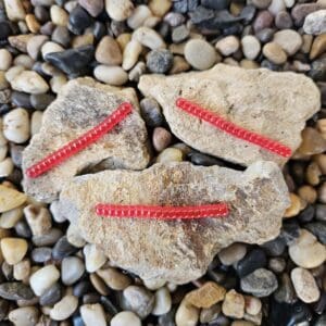 A face made of stones and red zipper details on pebbles.