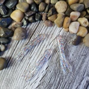 Three sparkly fishing lures on wood.